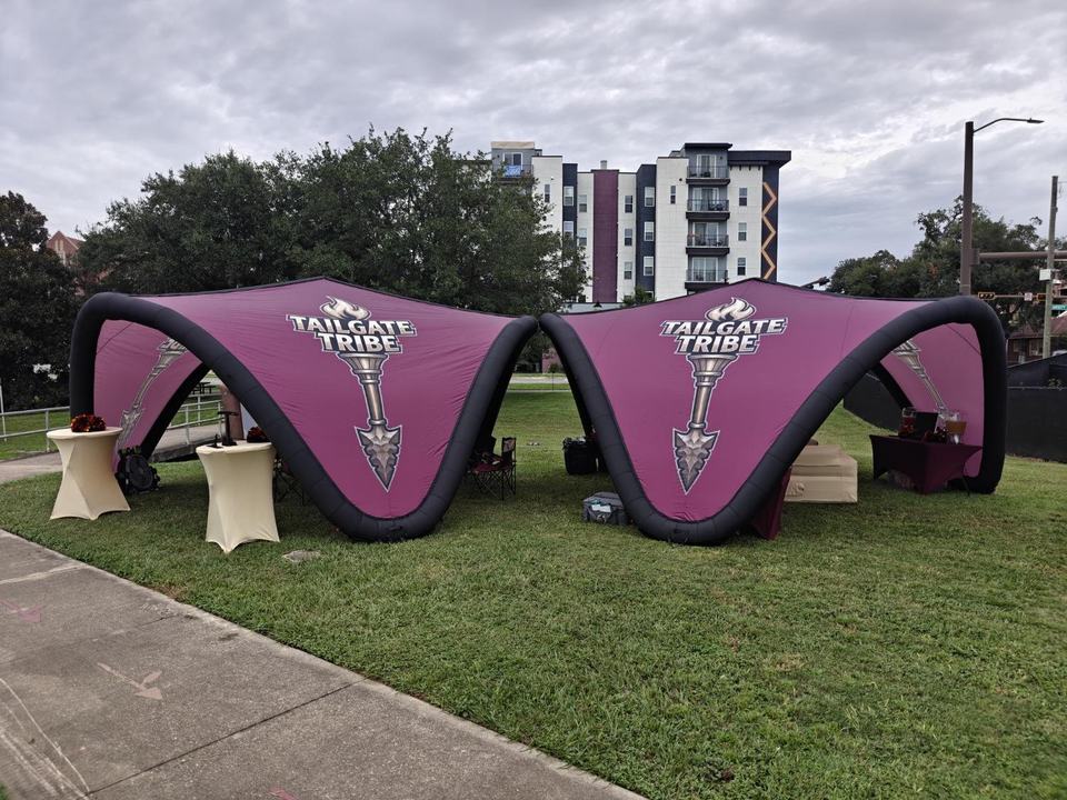 Two Tailgate Tribe inflatable canopies on the grass east of Lot 8