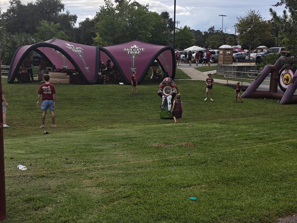 Both canopies, the tomahawk toss, and fans on the grass after the New Mexico State tailgate